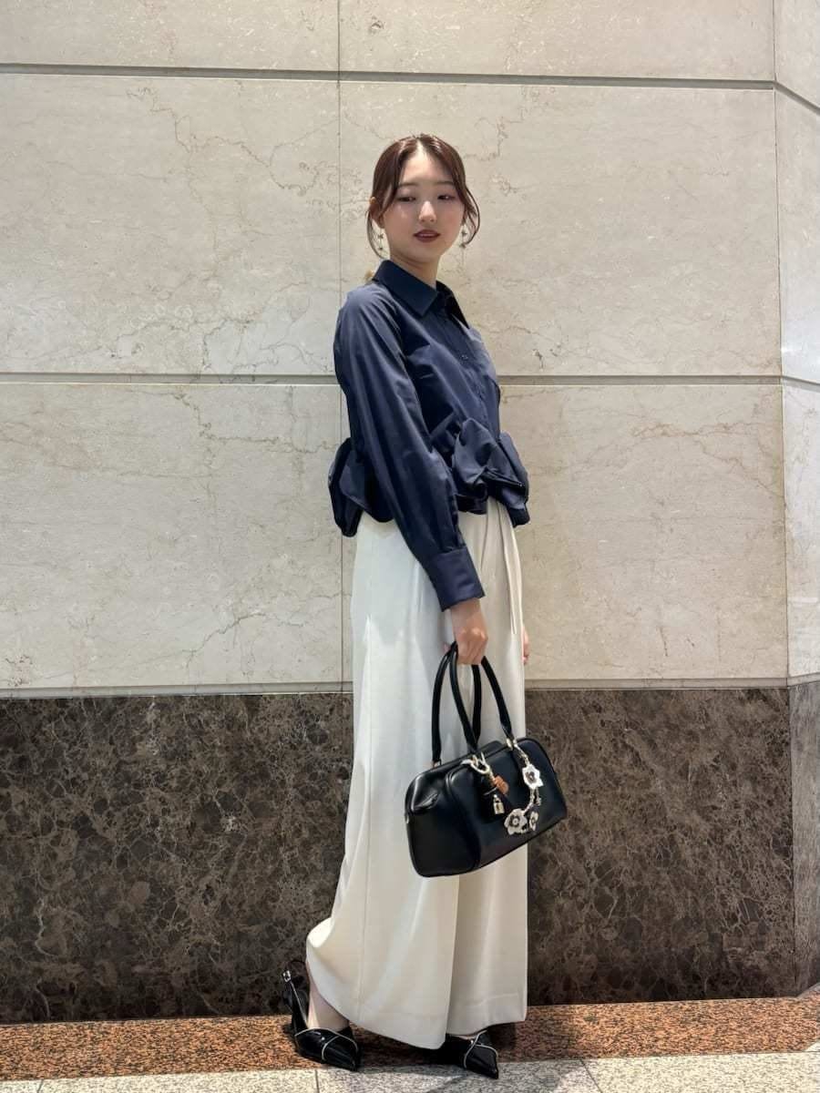 ホワイト系のその他パンツ、ブルー系のシャツ/ブラウス、ブラック系のパンプスを着用したレディースの冬コーディネートの3枚目の写真