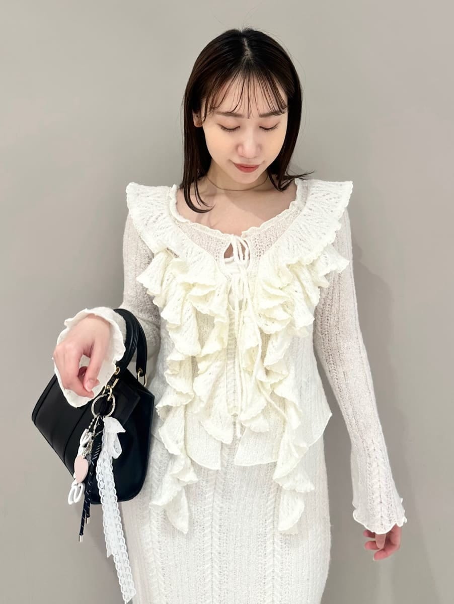 ホワイト系のスカート、ホワイト系のニット/セーター、ブラック系のハンドバッグを着用したレディースの秋コーディネートの2枚目の写真