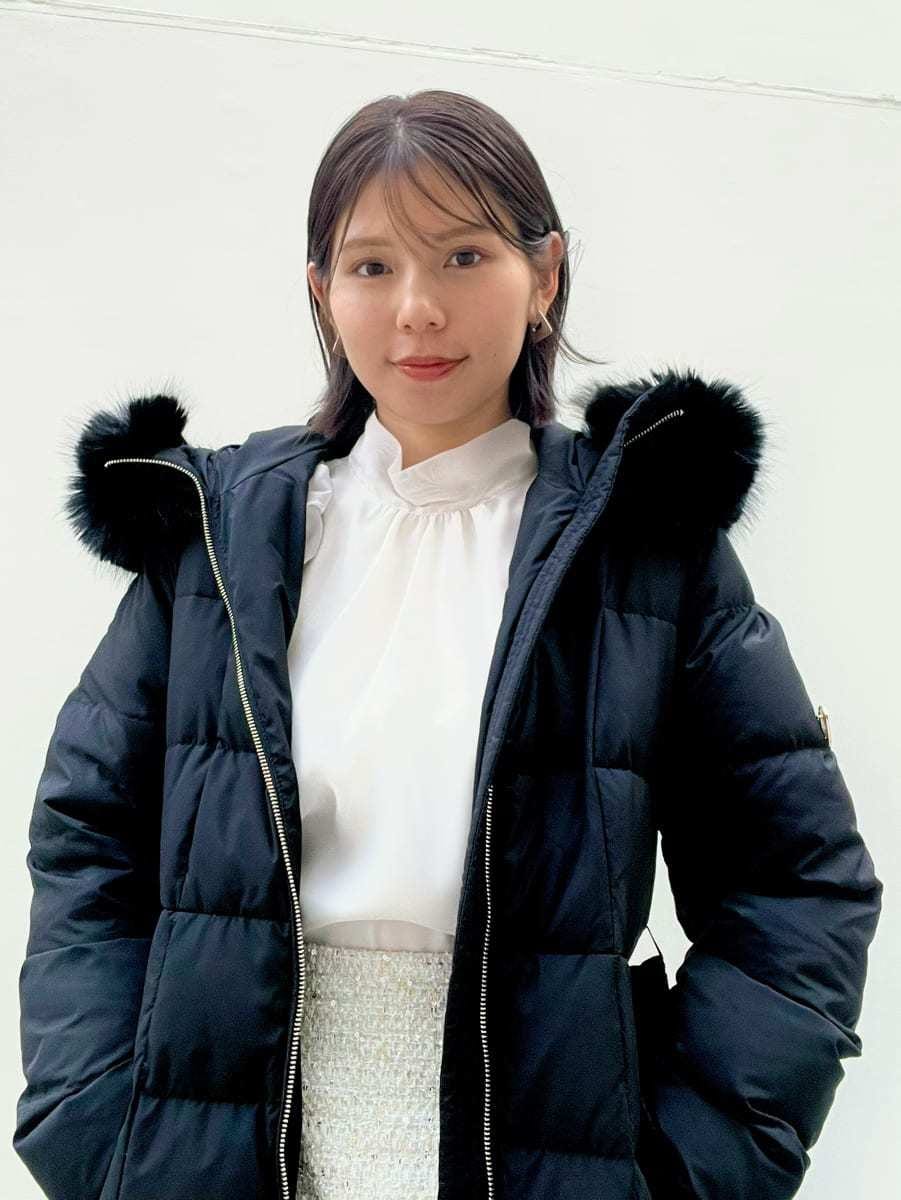 ホワイト系のスカート、ブラック系のブーツ、ブラック系のダウンジャケット/コートを着用したレディースの冬コーディネートの6枚目の写真