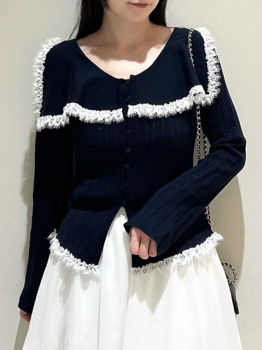 ブラック系のブーツ、ブラック系のショルダーバッグ、ホワイト系のスカートを着用したレディースの冬コーディネートの2枚目の写真