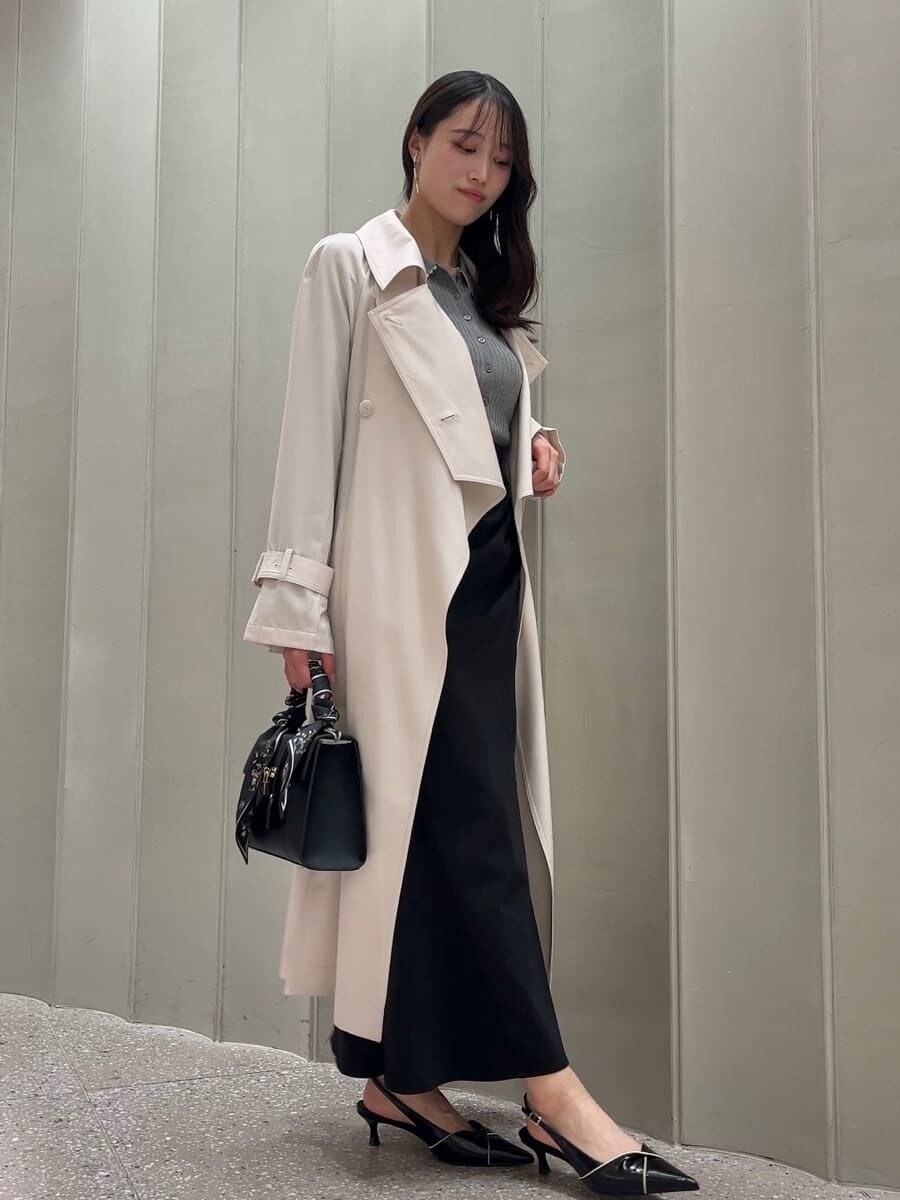 ホワイト系のトレンチコート、ブラック系のスカート、ブラック系のパンプスを着用したレディースの冬コーディネートの4枚目の写真