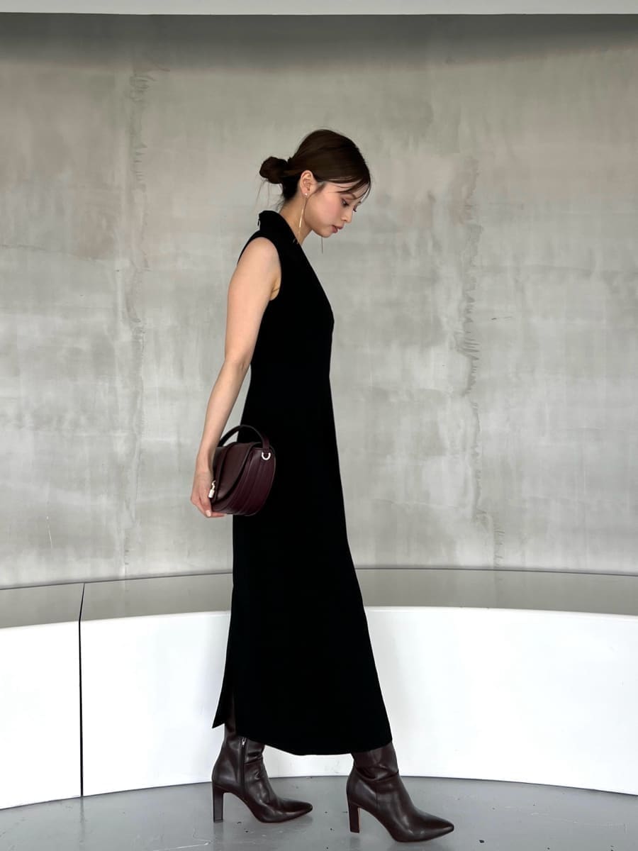 ブラック系のワンピース、ブラウン系のハンドバッグ、ブラウン系のブーツを着用したレディースの夏コーディネートの3枚目の写真