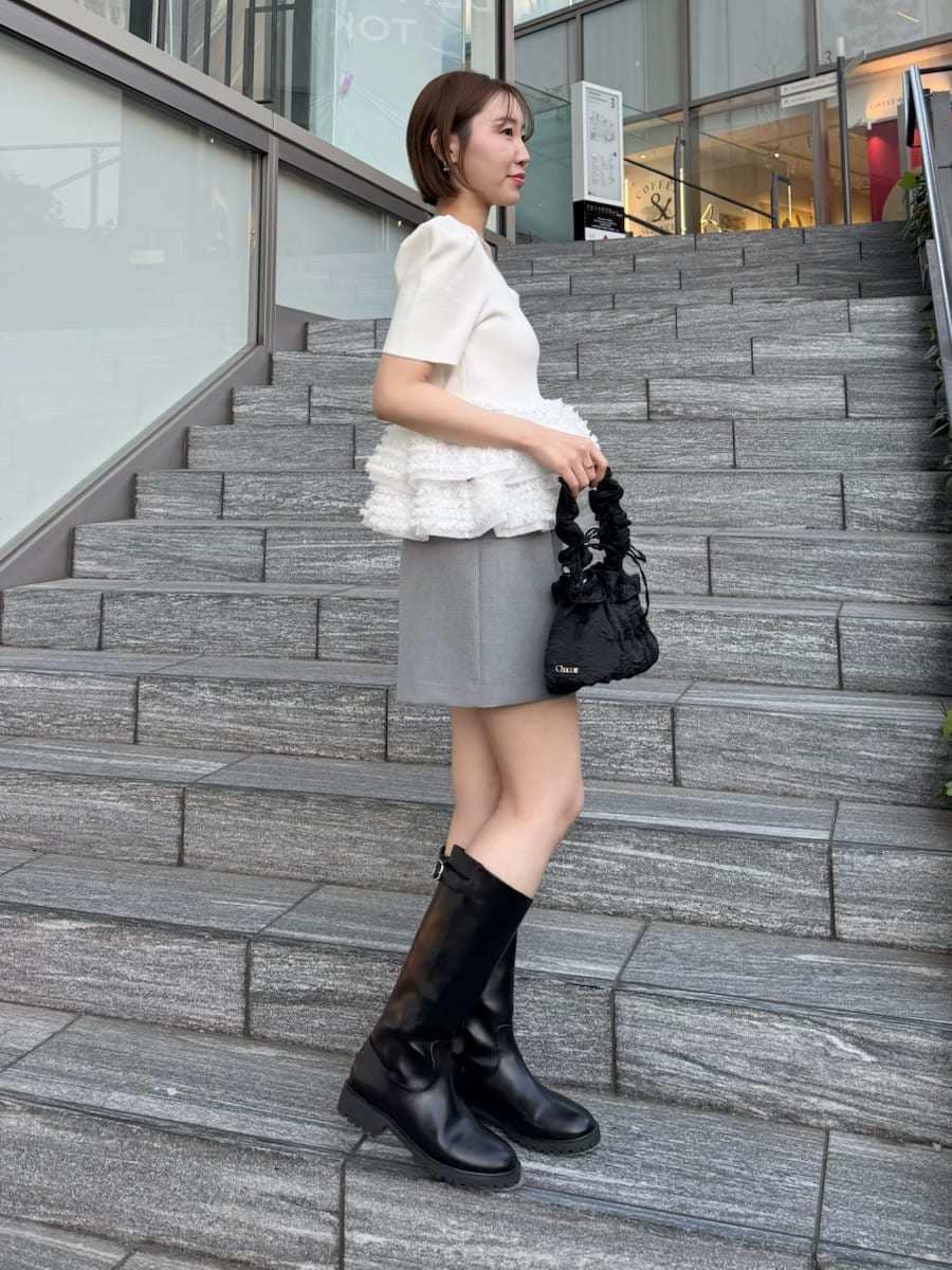 ホワイト系のニット/セーター、グレー系のその他パンツを着用したレディースの春コーディネートの4枚目の写真