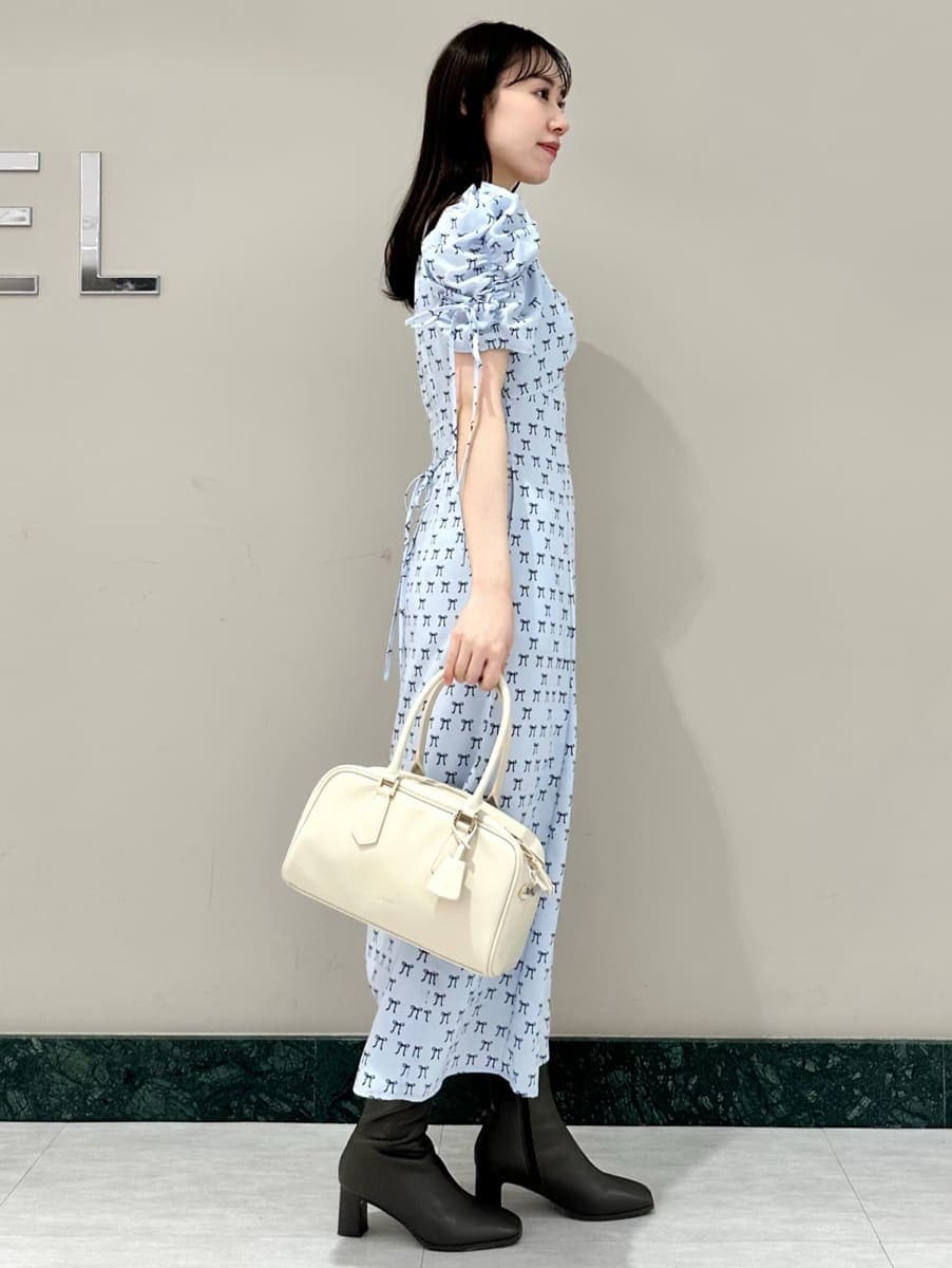 ブルー系のワンピース、ホワイト系のカーディガン/ボレロ、ホワイト系のボストンバッグを着用したレディースの冬コーディネートの3枚目の写真