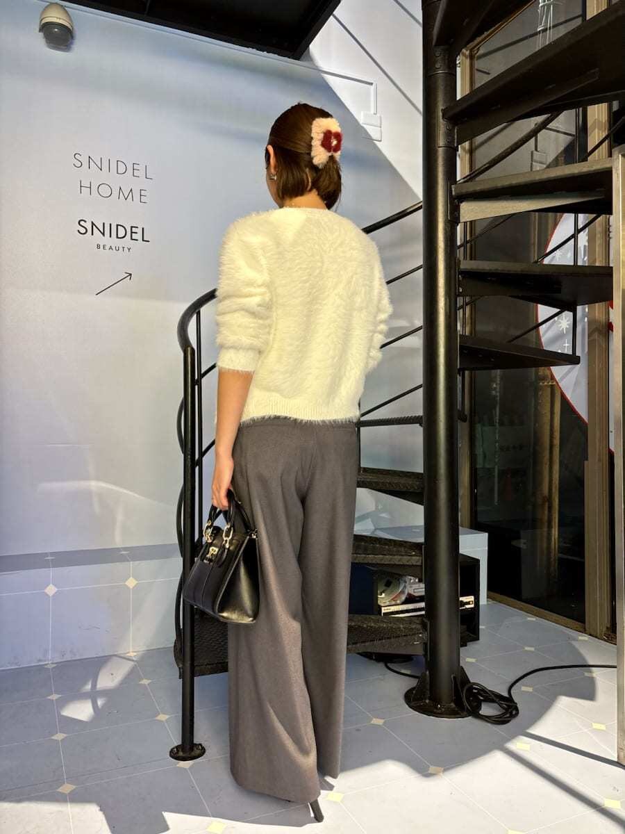 ブラック系のブーツ、ホワイト系のニット/セーター、ブラック系のハンドバッグを着用したレディースの秋コーディネートの4枚目の写真