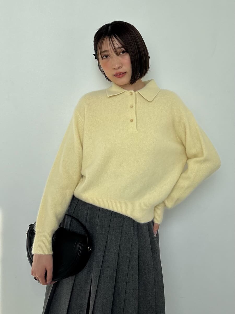 ブラック系のブーツ、ブラック系のハンドバッグ、イエロー系のニット/セーターを着用したレディースの秋コーディネートの7枚目の写真