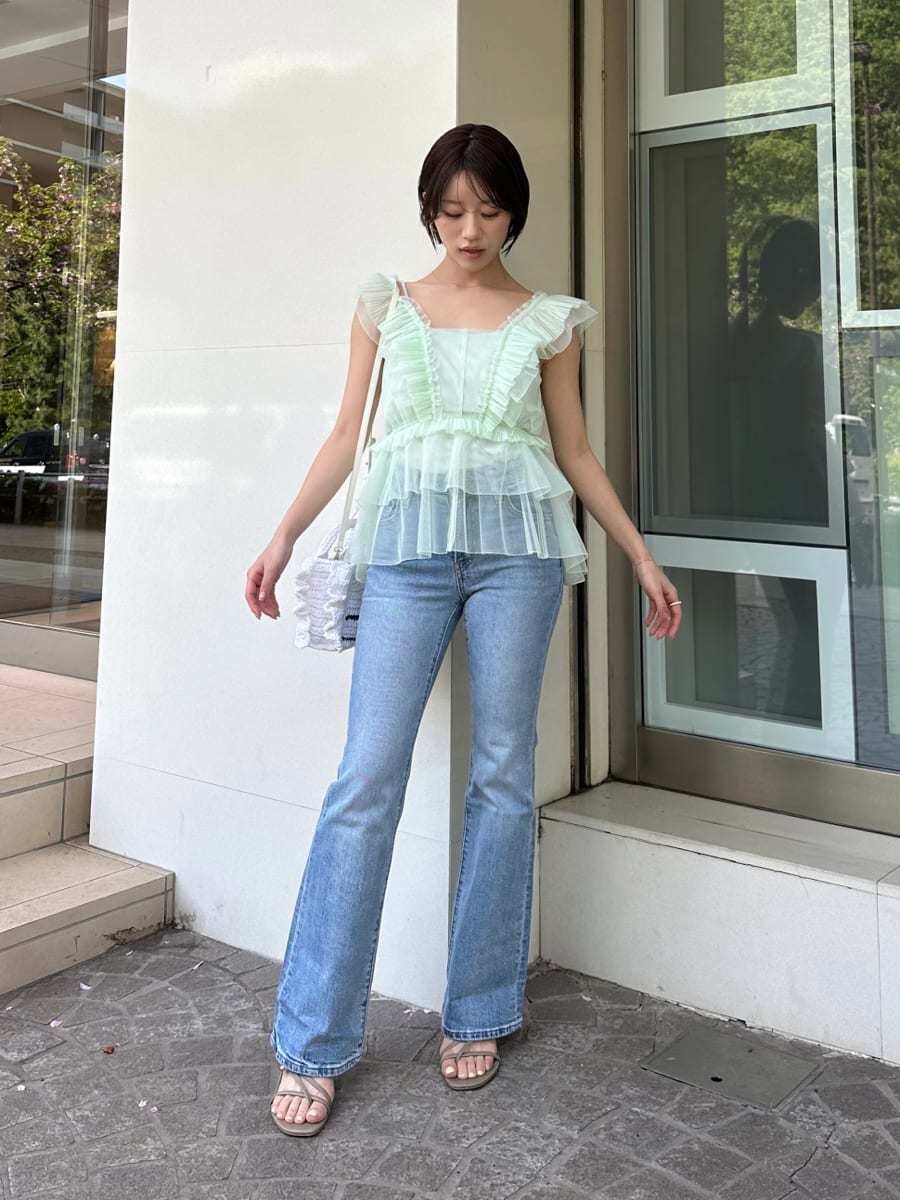 グリーン系のシャツ/ブラウス、ブルー系のデニムパンツ、ホワイト系のショルダーバッグを着用したレディースの春コーディネートの3枚目の写真