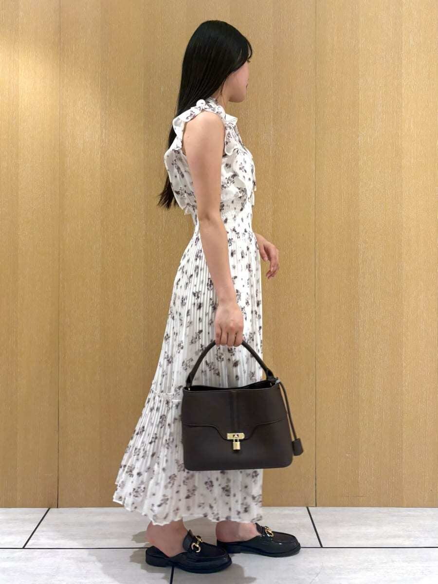 ブラウン系のハンドバッグ、ホワイト系のワンピースを着用したレディースの夏コーディネートの2枚目の写真