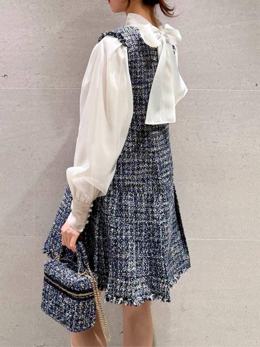 ブルー系のワンピース、ブルー系のハンドバッグ、その他のイヤリングを着用したレディースの冬コーディネートの4枚目の写真