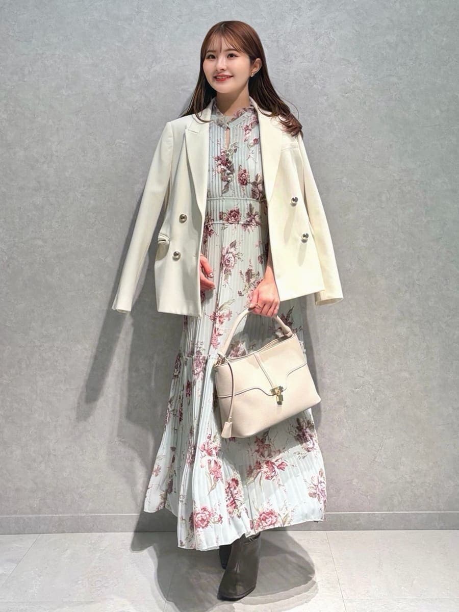 ホワイト系のテーラードジャケット、グリーン系のワンピース、ベージュ系のハンドバッグを着用したレディースの春コーディネートの4枚目の写真