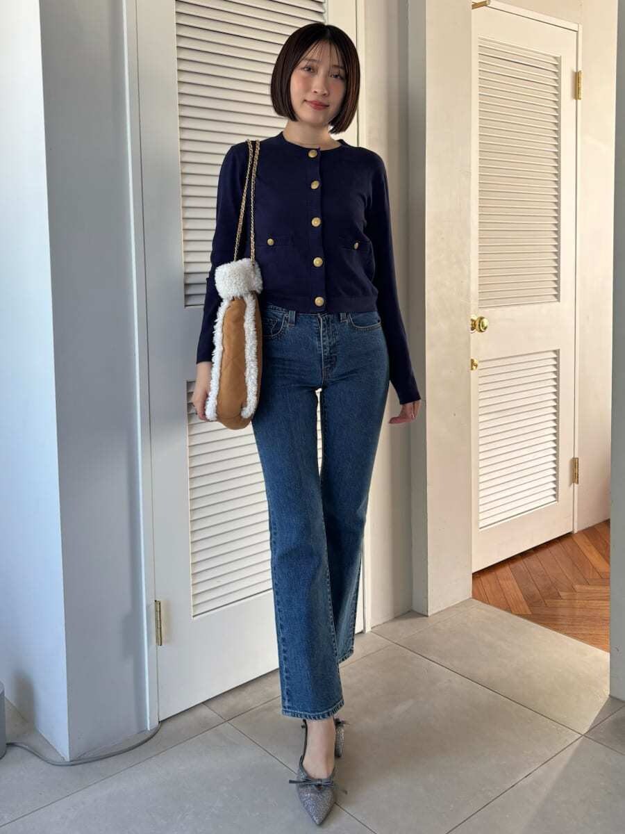 ブルー系のデニムパンツ、ブラウン系のハンドバッグを着用したレディースの秋コーディネートの6枚目の写真