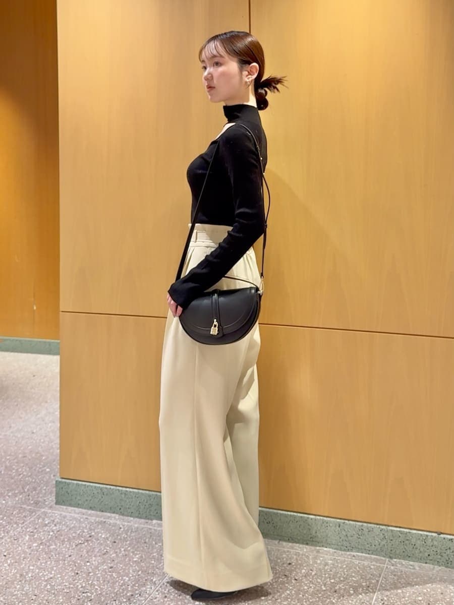 ホワイト系のカーディガン/ボレロ、ブラック系のニット/セーター、ブラック系のブーツを着用したレディースの秋コーディネートの5枚目の写真