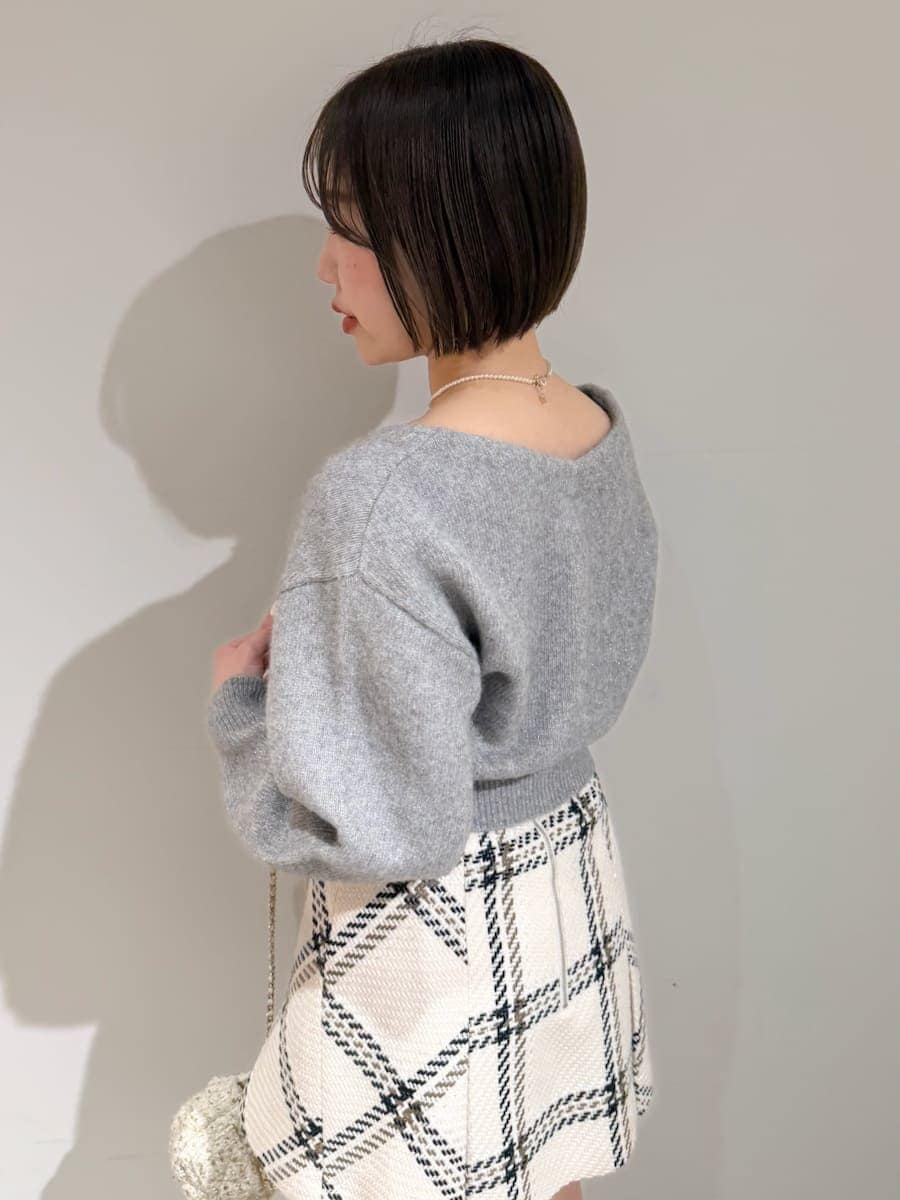 ホワイト系のスカート、グレー系のカーディガン/ボレロ、ゴールド系のキーケース/キーアクセサリーを着用したレディースの冬コーディネートの9枚目の写真