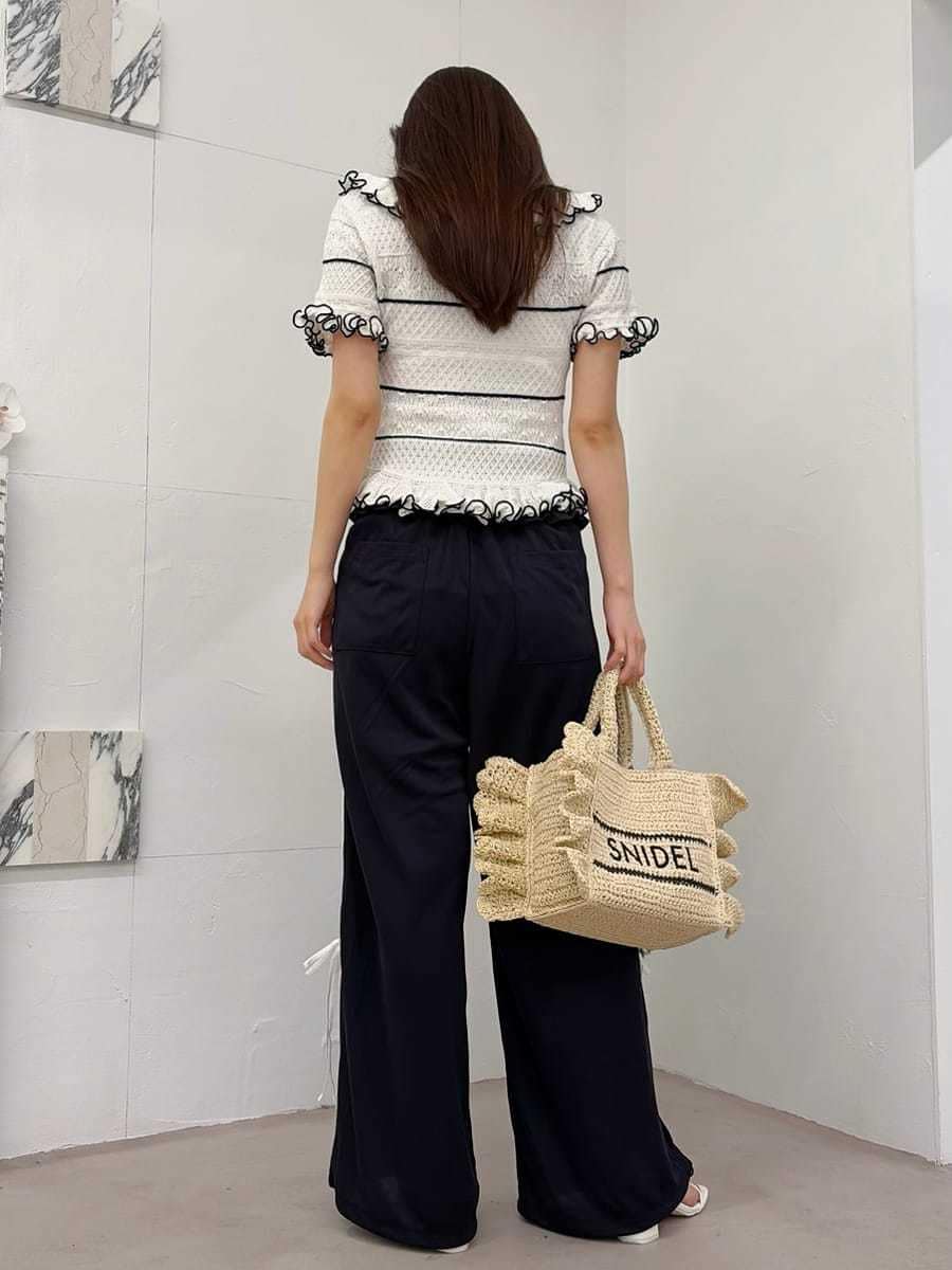 ベージュ系のショルダーバッグ、ブルー系のその他パンツ、ホワイト系のニット/セーターを着用したレディースの春コーディネートの4枚目の写真