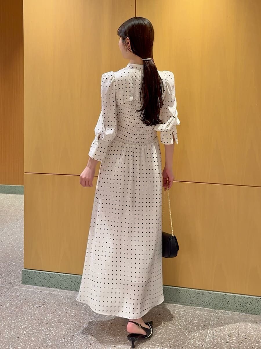 ブラック系のパンプス、ブラック系のショルダーバッグ、ホワイト系のワンピースを着用したレディースの春コーディネートの3枚目の写真