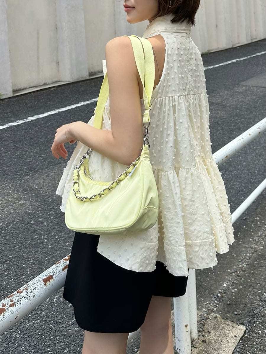 ブラック系のその他パンツ、ホワイト系のシャツ/ブラウス、イエロー系のショルダーバッグを着用したレディースの春コーディネートの5枚目の写真
