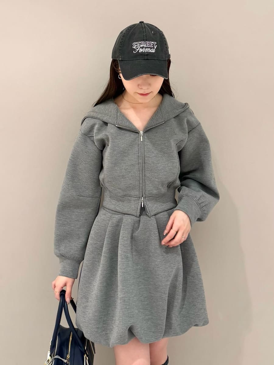 グレー系のワンピース、ブルー系のボストンバッグ、ブラック系のローファーを着用したレディースの冬コーディネートの4枚目の写真