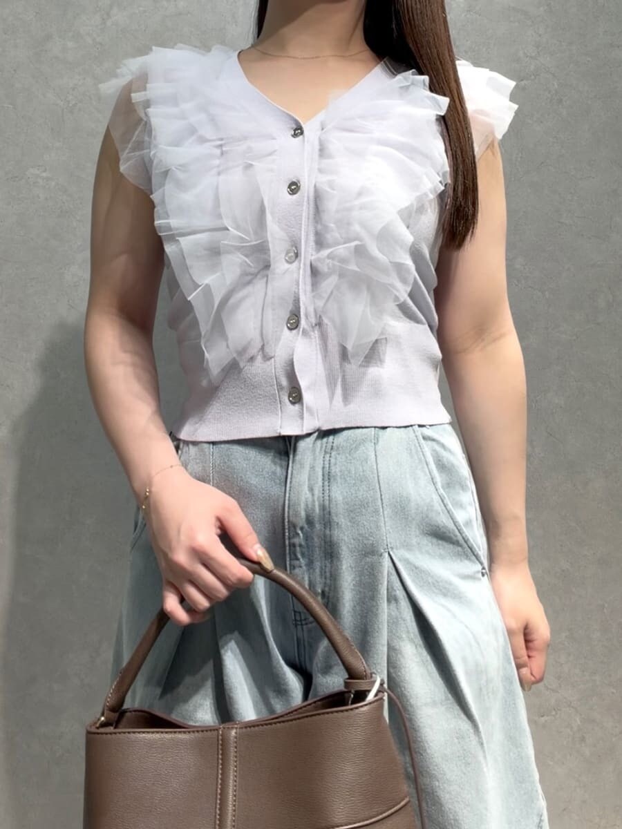ブラウン系のハンドバッグ、ブルー系のデニムパンツ、パープル系のニット/セーターを着用したレディースの夏コーディネートの5枚目の写真