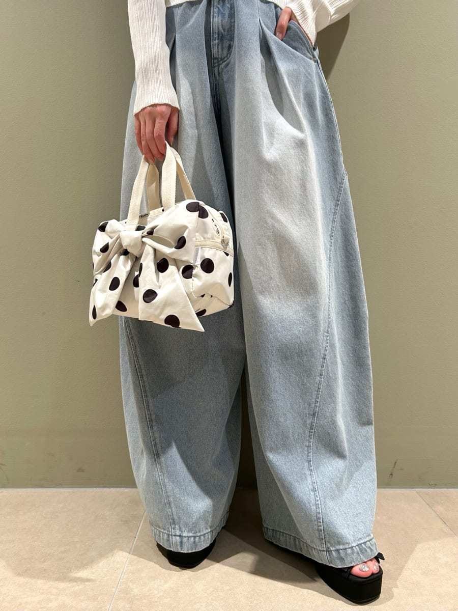 ホワイト系のニット/セーター、ホワイト系のショルダーバッグ、ブルー系のデニムパンツを着用したレディースの夏コーディネートの7枚目の写真