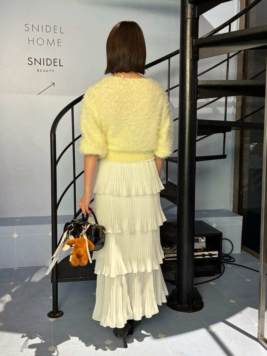 ブラック系のブーツ、ブラック系のボストンバッグ、イエロー系のニット/セーターを着用したレディースの冬コーディネートの3枚目の写真