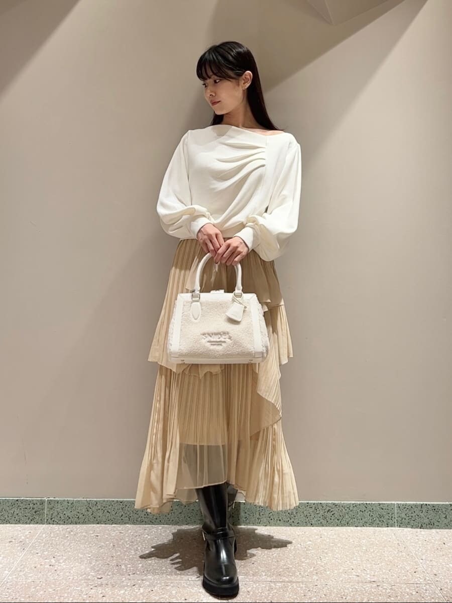 ホワイト系のTシャツ/カットソー、イエロー系のスカート、ホワイト系のハンドバッグを着用したレディースの秋コーディネートの6枚目の写真