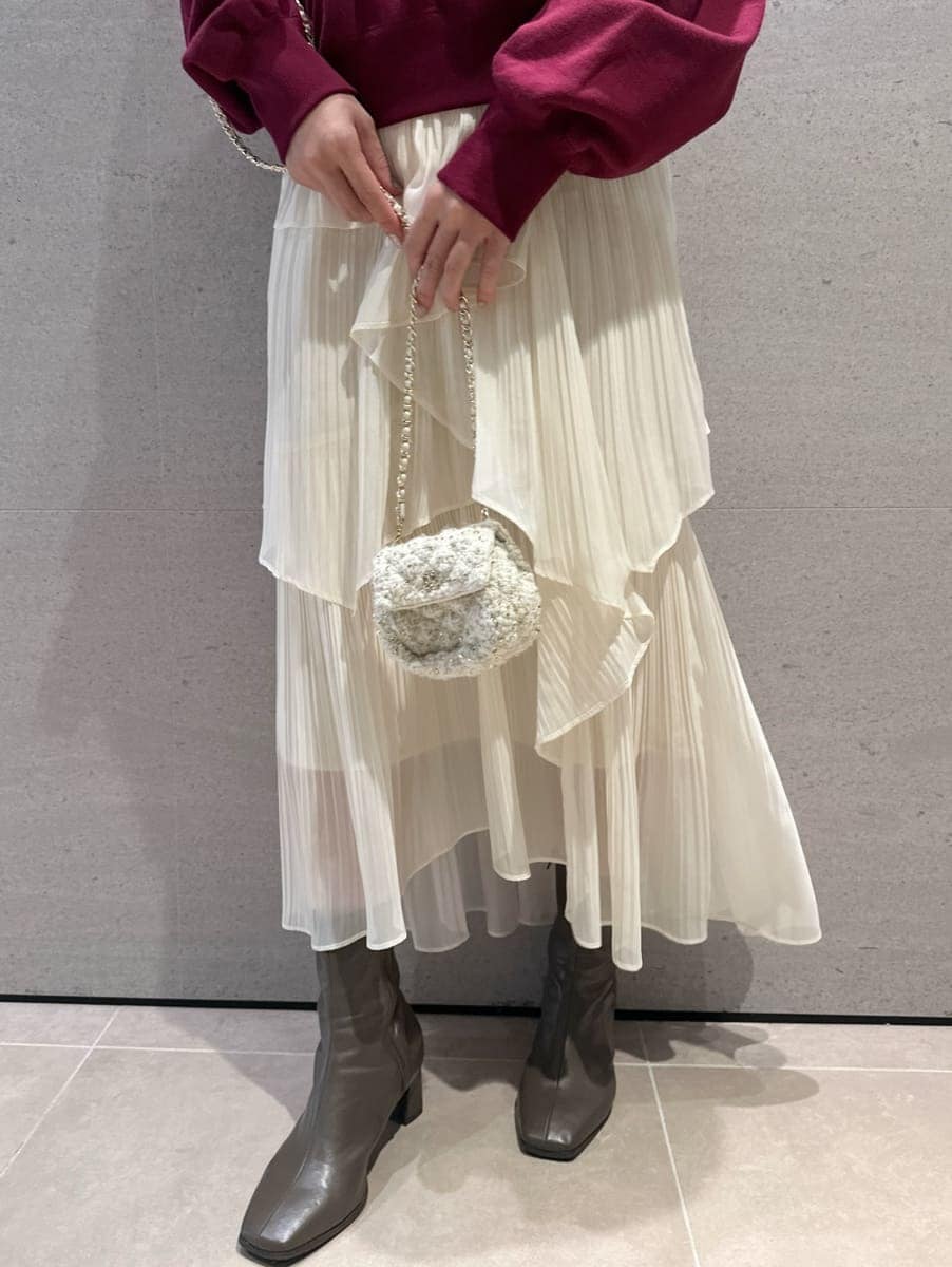 レッド系のスウェット、ホワイト系のスカート、ホワイト系のショルダーバッグを着用したレディースの秋コーディネートの3枚目の写真