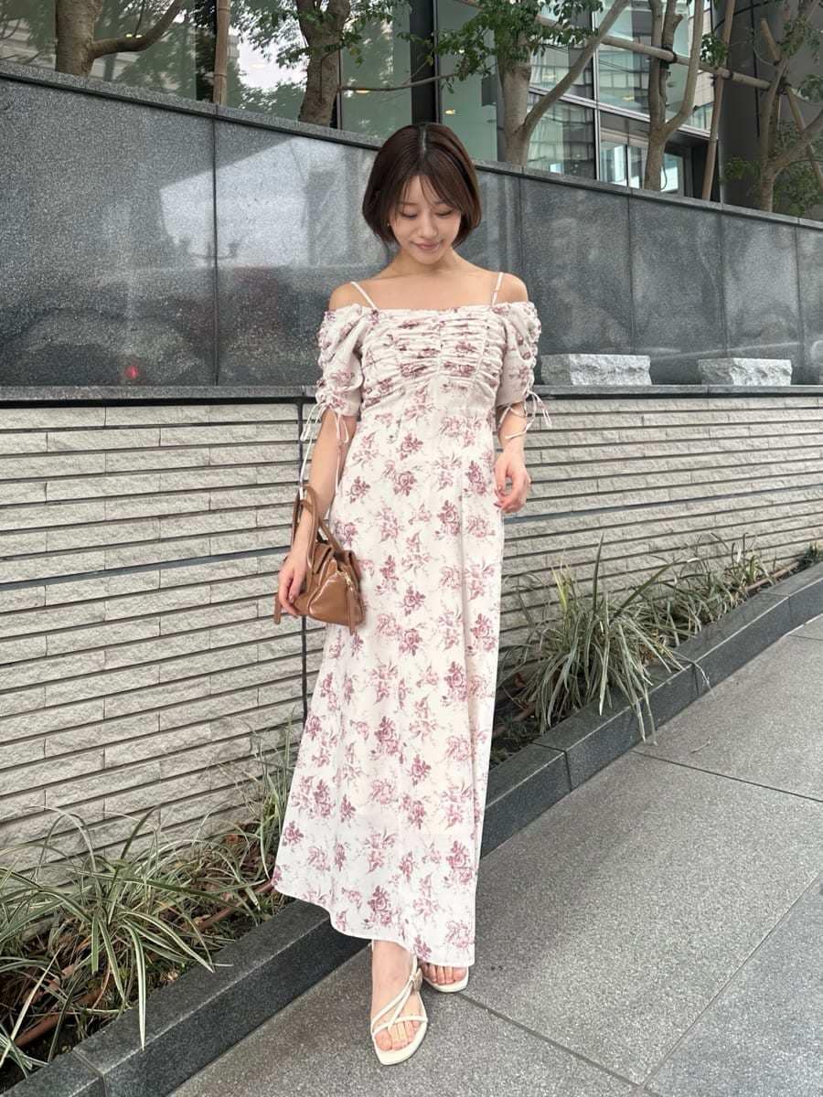 イエロー系のボストンバッグ、ピンク系のワンピースを着用したレディースの冬コーディネートの6枚目の写真