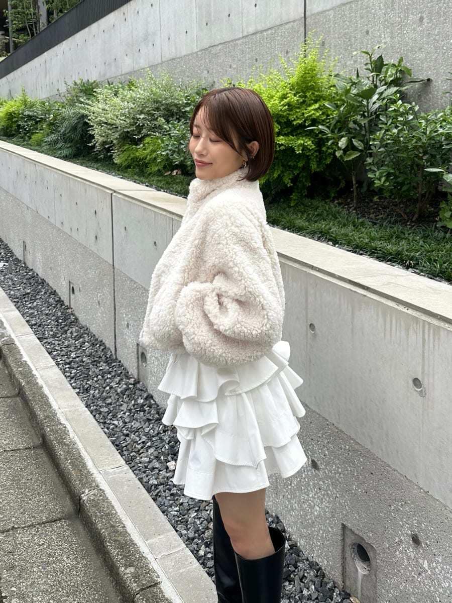 ホワイト系のその他パンツ、ブラック系のブーツ、ブラック系のショルダーバッグを着用したレディースの秋コーディネートの4枚目の写真