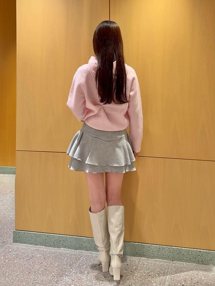 ホワイト系のショルダーバッグ、ピンク系のニット/セーター、ホワイト系のブーツを着用したレディースの冬コーディネートの6枚目の写真