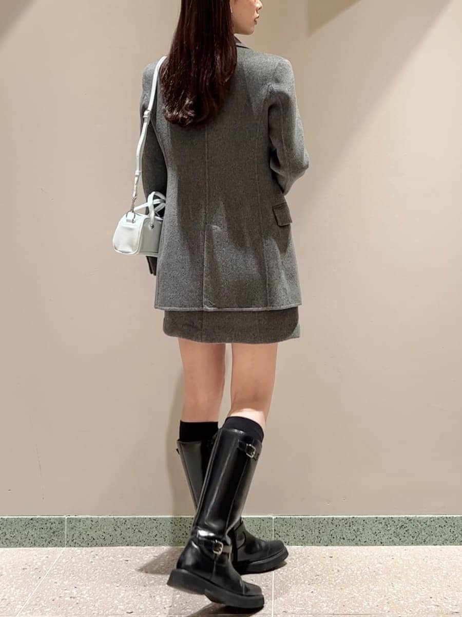 ブラック系のブーツ、グレー系のテーラードジャケット、グレー系のワンピースを着用したレディースの秋コーディネートの5枚目の写真