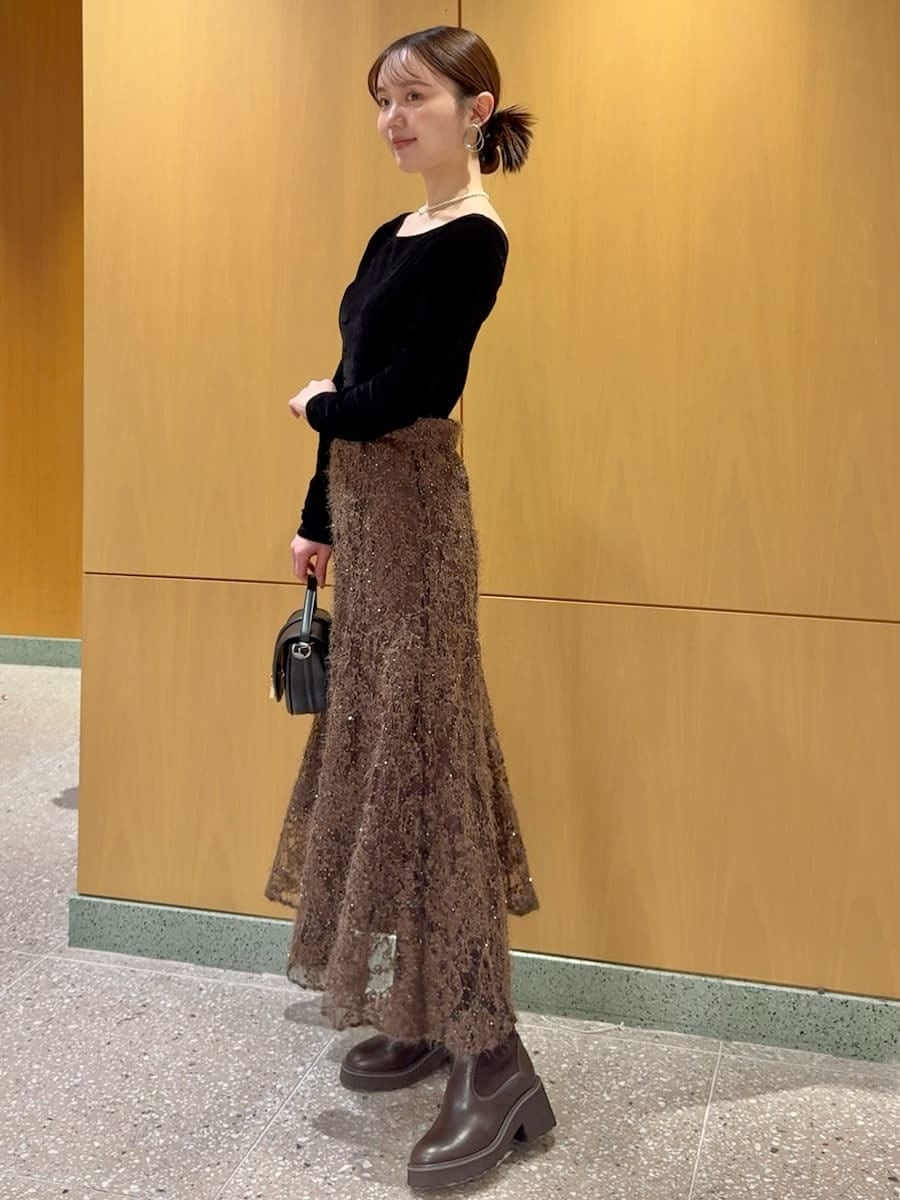 ブラック系のTシャツ/カットソー、ブラウン系のスカート、ブラック系のハンドバッグを着用したレディースの秋コーディネートの2枚目の写真