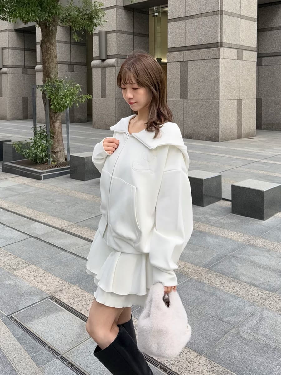 ブラック系のブーツ、ホワイト系のパーカー、ホワイト系のハンドバッグを着用したレディースの冬コーディネートの5枚目の写真