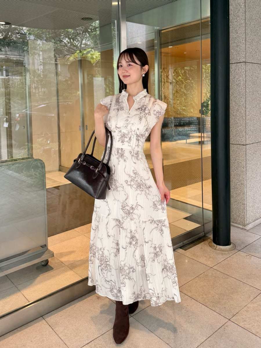 ホワイト系のワンピース、ブラウン系のカーディガン/ボレロ、ブラウン系のブーツを着用したレディースの秋コーディネートの3枚目の写真