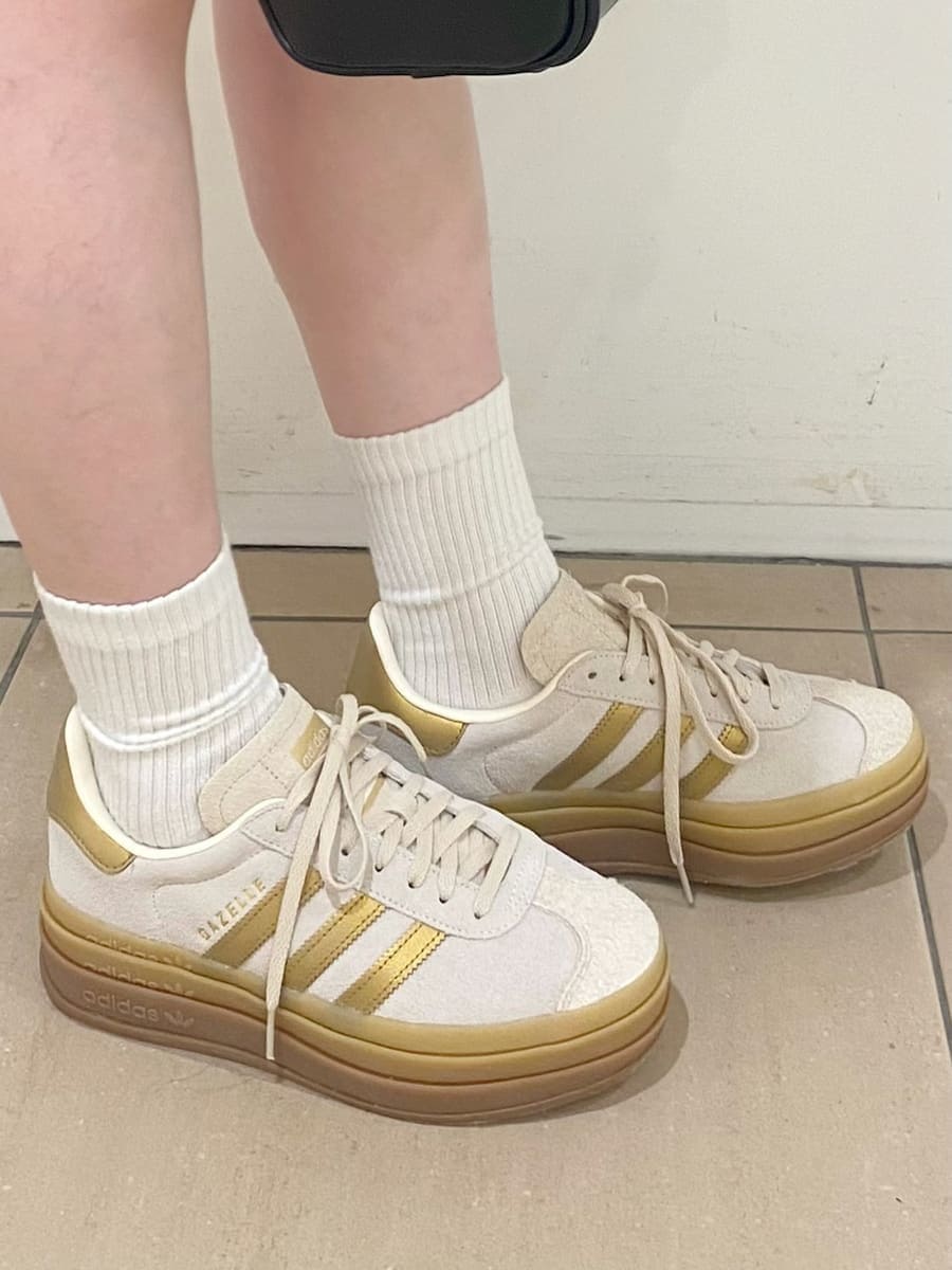 ベージュ系のブルゾン、ブラック系のボストンバッグ、ゴールド系のスニーカーを着用したレディースの冬コーディネートの4枚目の写真