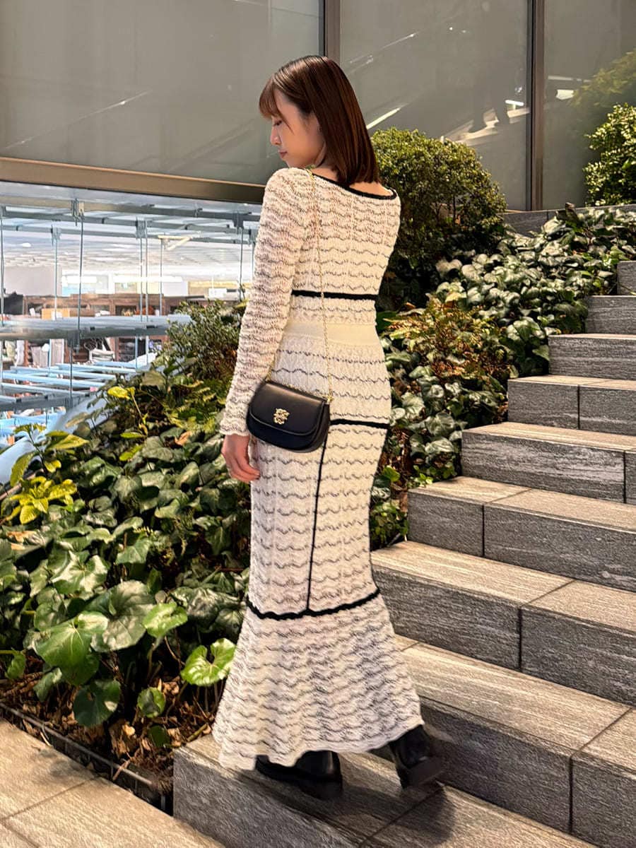 その他のスカート、その他のニット/セーター、ブラック系のショルダーバッグを着用したレディースの春コーディネートの5枚目の写真