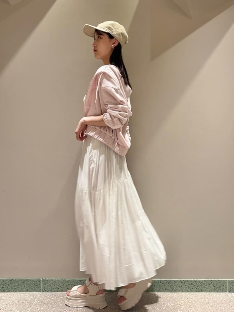 ピンク系のパーカー、ピンク系のタンクトップ、ホワイト系のスカートを着用したレディースの夏コーディネートの5枚目の写真