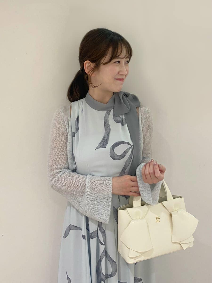 ブルー系のワンピース、その他のパンプス、ホワイト系のハンドバッグを着用したレディースの冬コーディネートの4枚目の写真