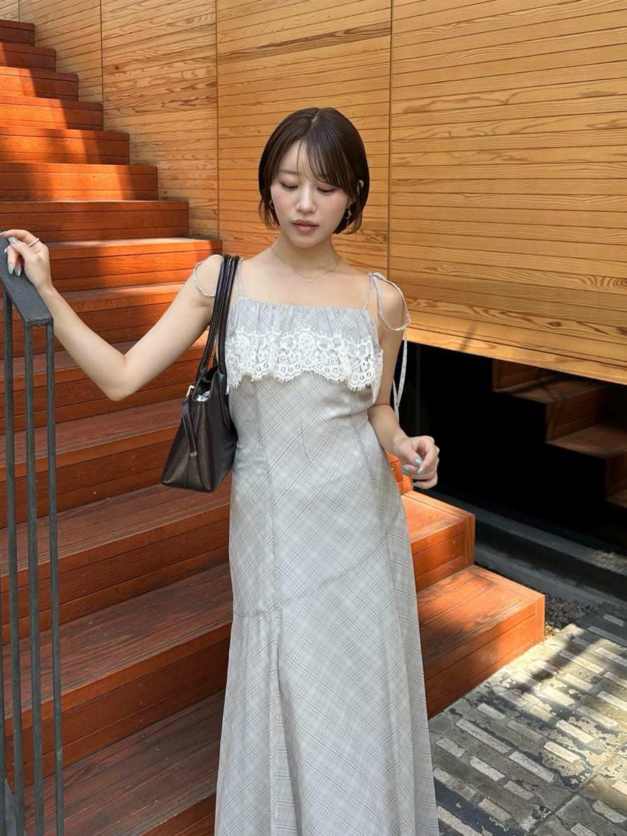ベージュ系のワンピース、ブラウン系のブーツ、ブラウン系のボストンバッグを着用したレディースの夏コーディネートの4枚目の写真
