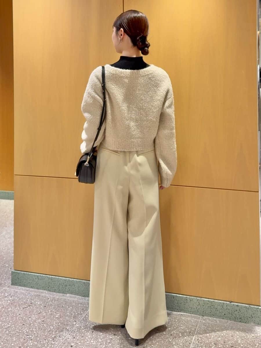 ホワイト系のカーディガン/ボレロ、ブラック系のニット/セーター、ブラック系のブーツを着用したレディースの秋コーディネートの3枚目の写真