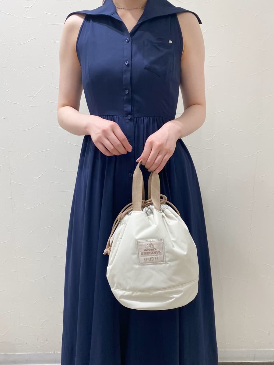 ブルー系のワンピース、ベージュ系のハンドバッグ、ホワイト系のパンプスを着用したレディースの夏コーディネートの3枚目の写真