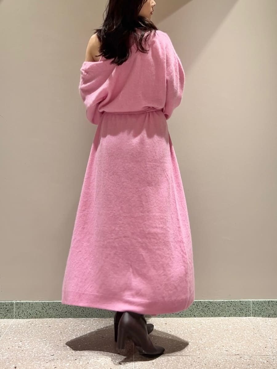 レッド系のブーツ、ピンク系のチェスターコート、ピンク系のワンピースを着用したレディースの冬コーディネートの3枚目の写真