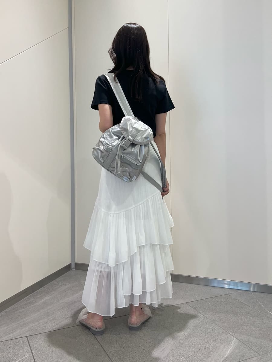 ホワイト系のスカート、シルバー系のバックパック/リュック、ブルー系のTシャツ/カットソーを着用したレディースの春コーディネートの4枚目の写真