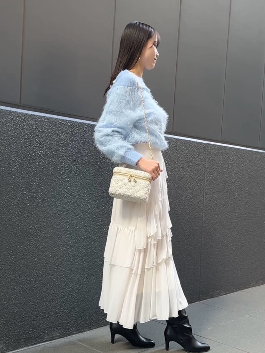 ホワイト系のスカート、ホワイト系のハンドバッグを着用したレディースの冬コーディネートの5枚目の写真