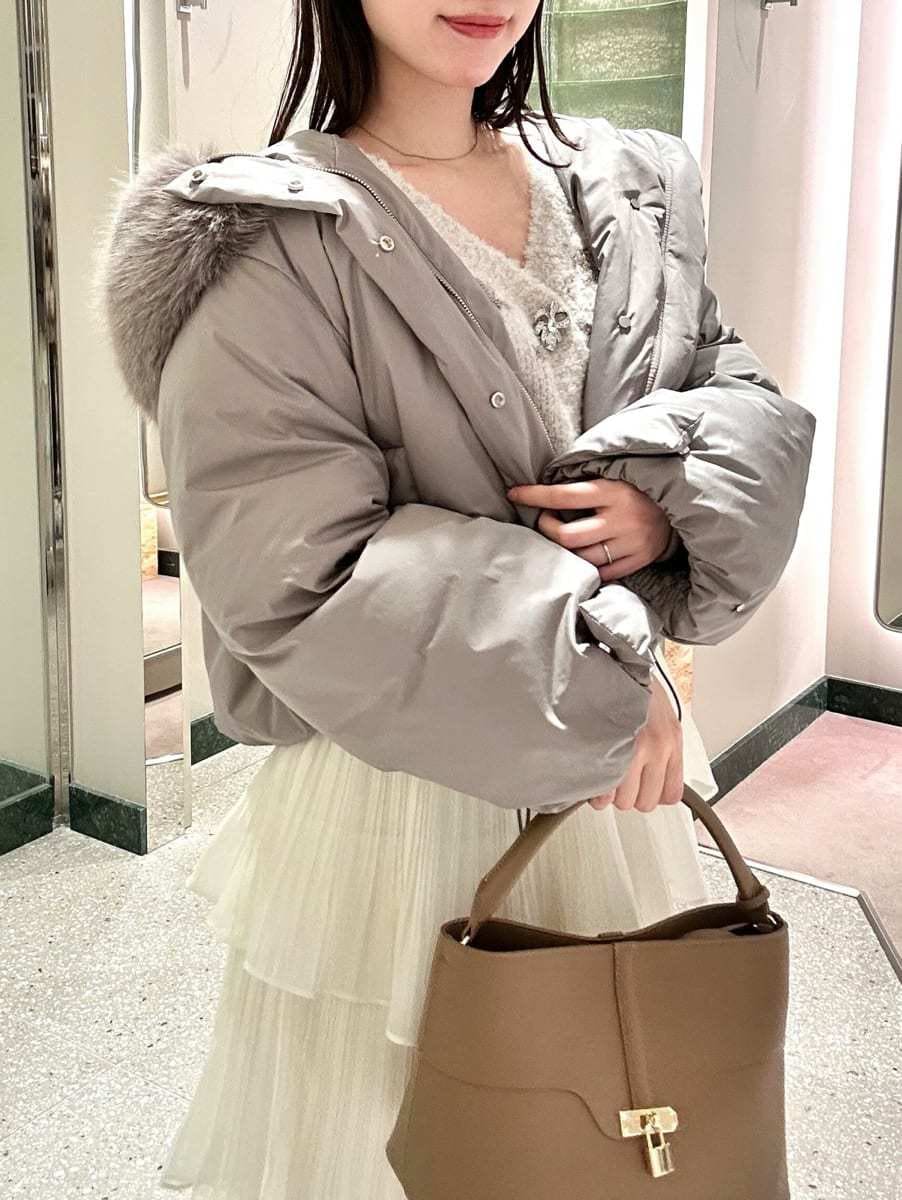 グレー系のダウンジャケット/コート、ホワイト系のスカート、その他のカーディガン/ボレロを着用したレディースの秋コーディネートの3枚目の写真