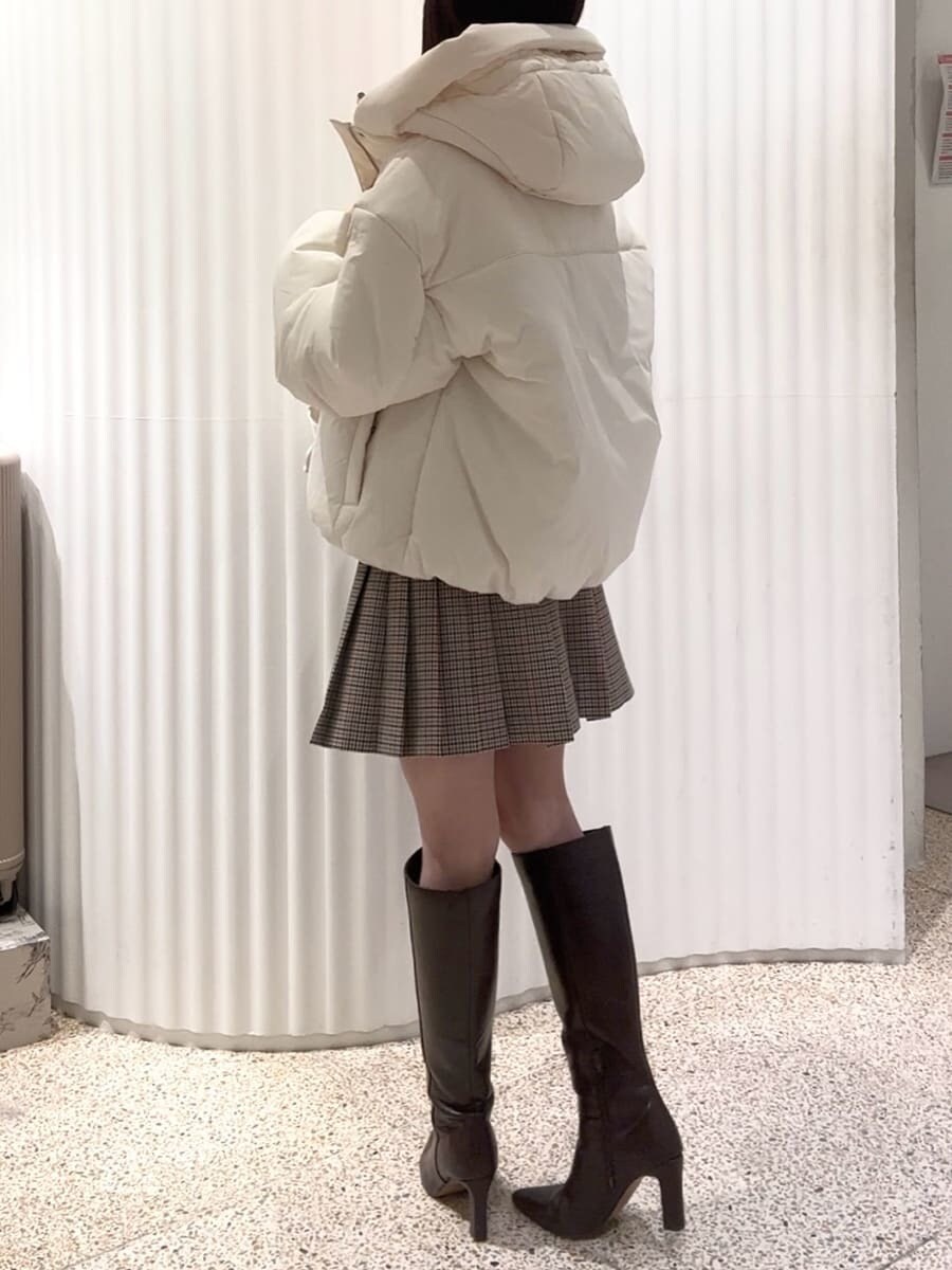 ベージュ系のスカート、ブラウン系のブーツ、ホワイト系のダウンジャケット/コートを着用したレディースの秋コーディネートの2枚目の写真