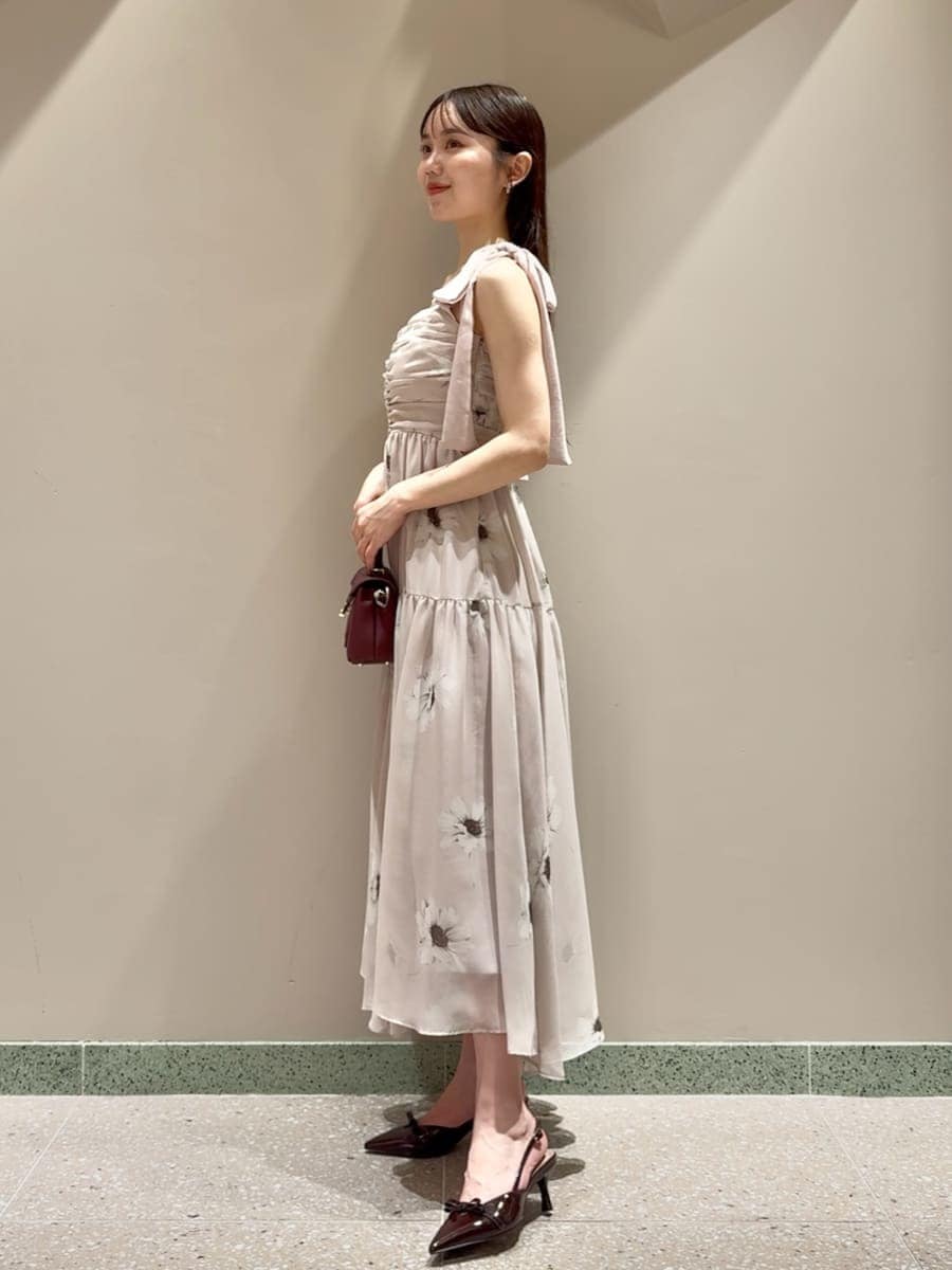 ピンク系のワンピース、ブラウン系のショルダーバッグ、シルバー系のピアス（両耳用）を着用したレディースの夏コーディネートの2枚目の写真