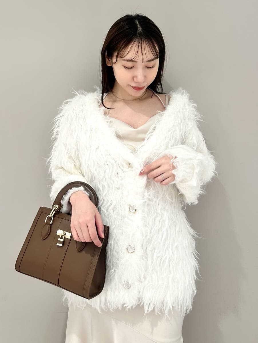 ホワイト系のワンピース、ホワイト系のカーディガン/ボレロ、ブラウン系のハンドバッグを着用したレディースの秋コーディネートの3枚目の写真