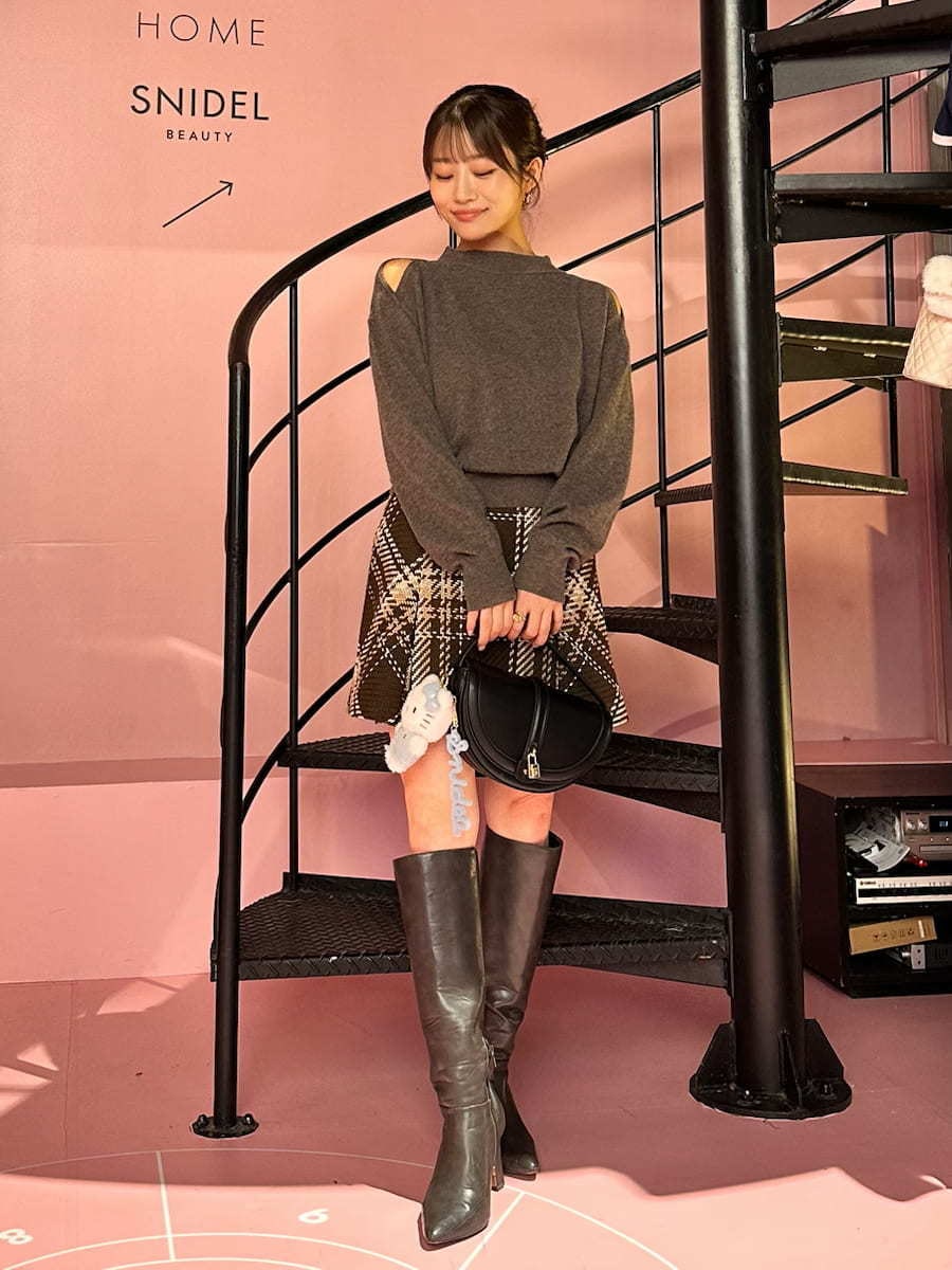 ブラウン系のニット/セーター、ブラウン系のスカート、グレー系のブーツを着用したレディースの秋コーディネートの3枚目の写真