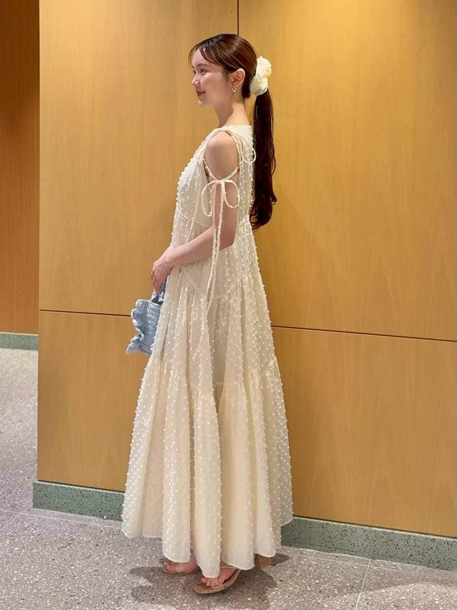 ブルー系のショルダーバッグ、ホワイト系のワンピース、その他のサンダルを着用したレディースの夏コーディネートの2枚目の写真