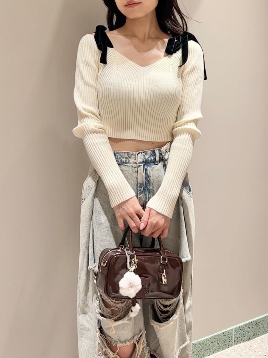 ホワイト系のニット/セーター、ブルー系のデニムパンツ、ブラウン系のボストンバッグを着用したレディースの秋コーディネートの5枚目の写真